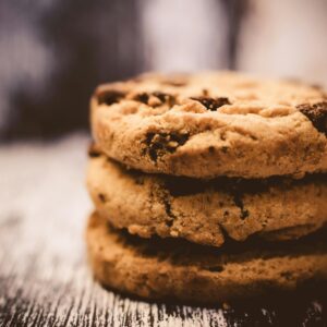 A macro shot of freshly baked stacked chocolate chip cookies creates a cozy dessert vibe.