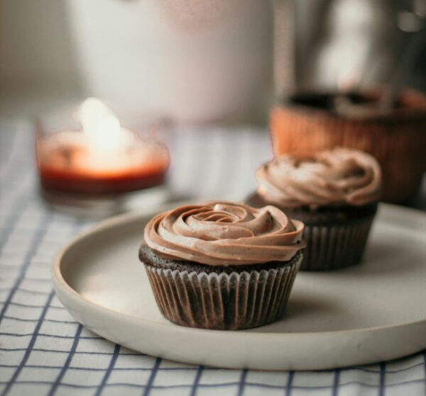 Delicious chocolate cupcakes with swirled frosting on a plate, perfect dessert for teatime.